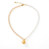 Pearl and gemstone gold necklace displayed with matching earrings